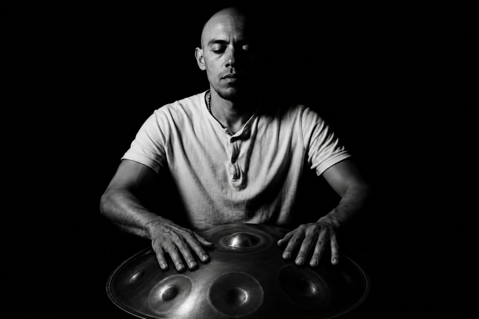 Israel, artesano de handpans SHIVAPAN, tocando uno de sus handpans en Tulum, México